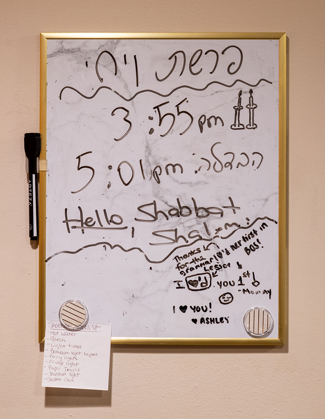 Photo of eraser board stating when the next Shabbat begins and ends in a messy scrawl.
