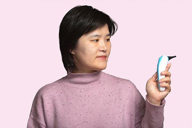 Alum Jane Zhang, co-founder and CEO of Remmie Health holds the ear infection detection device she designed. Photo by Ron Wurzer for Boston University Photography