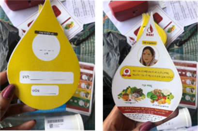 Photos: Left photo shows the back of a tear-shaped card that has 3 blank white boxes to write in information on a yellow background.  The right photo shows the front of the card with illustrations of an Indian woman and various fruits and vegetables. 