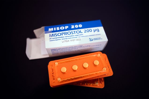 Photo of the drug misoprostol sitting on a gynecological table at Casa Fusa, a health center in Buenos Aires, Argentina, Friday, Jan. 22, 2021. A blue and white box reads: "MISOP 200: Misoprostol 200g" and an orange package with 4 pills is seen in front.