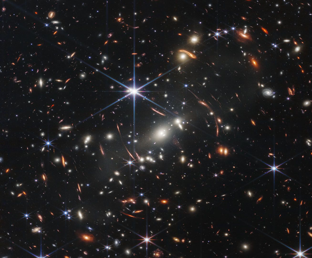 Photo of Webb’s First Deep Field. A large cluster of bright, multicolored dots and light are shown in space.