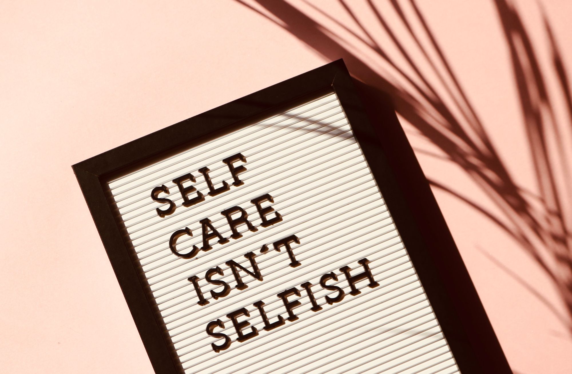 black and white sign that says self-care isn't selfish