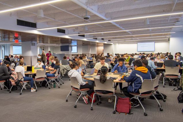 Photo of First-year medical students in the new $5.5 million Learning Center attending a class on gene expression August 22. Students sit in groups around large tables as they work together.