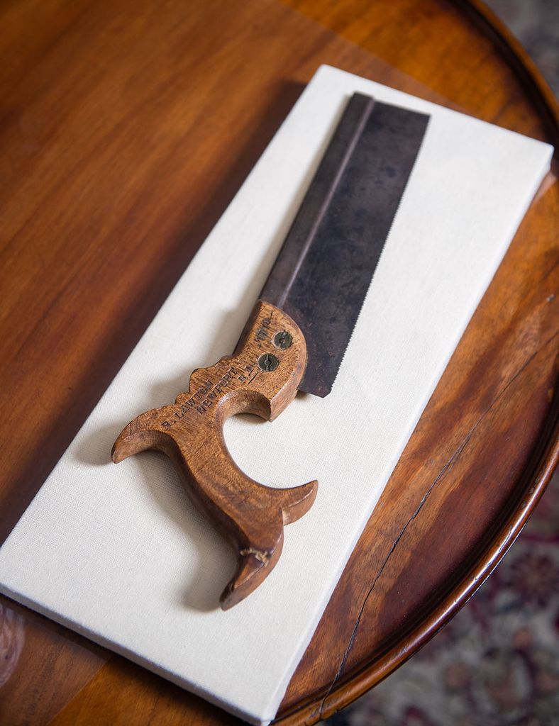 Photo: Photo of an old saw with an ornately shaped wooden handle.