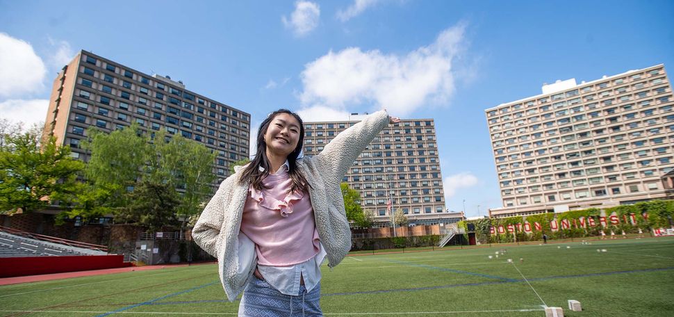 Roubing Liao (CGS’22, CAS’24) stands on Nickerson Field in front of the three residential towers comprising West Campus—Rich, Sleeper, and Claflin Halls, named for BU’s founders: Isaac Rich, Jacob Sleeper, and Lee Claflin.