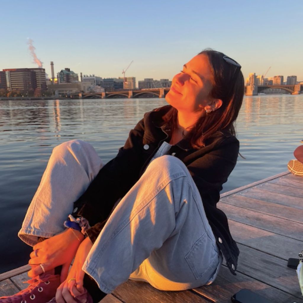 Photo of Paulina Preciat Jasso sitting on a dock located at Boston's esplanade