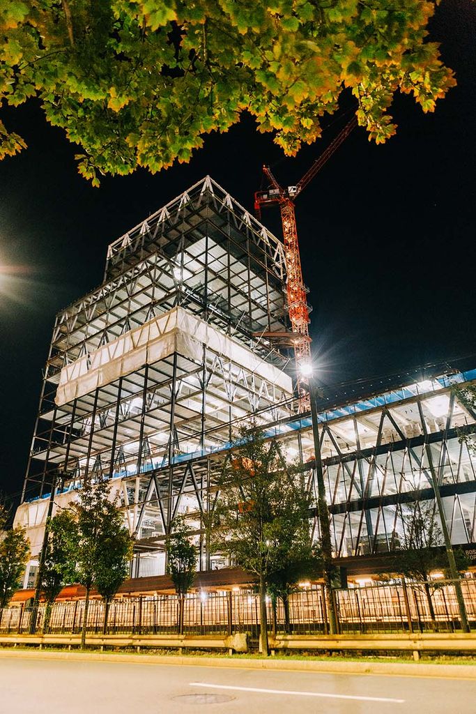 Photo: Construction of the Center for Computing & Data Sciences. The metal framework of the building is shown lit up during the night.