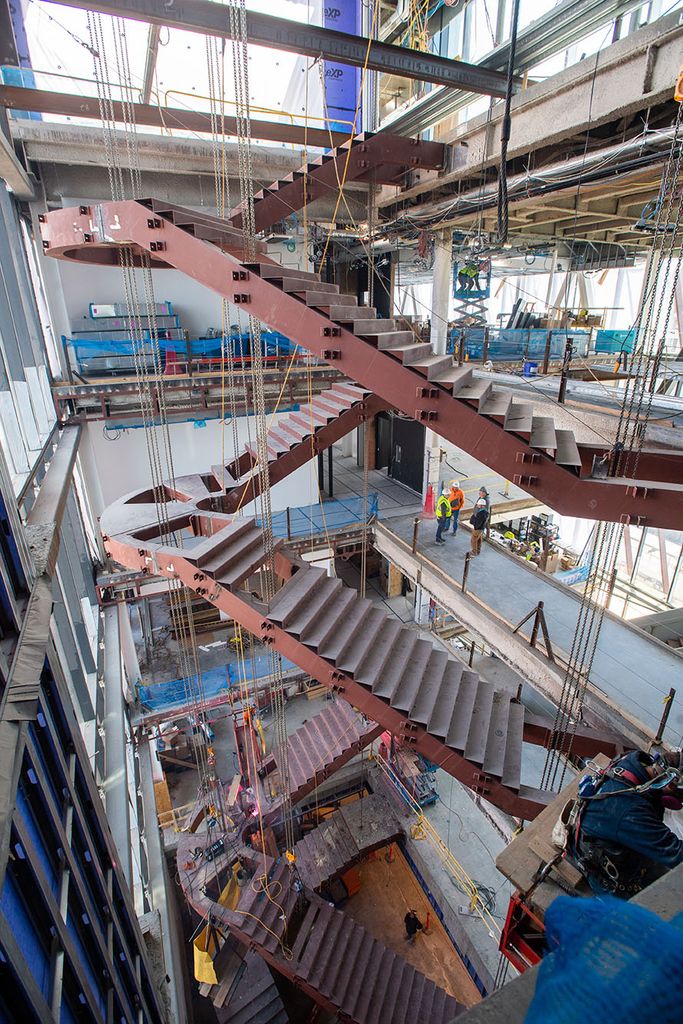 Photo: Interior of the Center for Computing and Data Science as work continues to be done. A winding staircase can be seen taking shape in the cluttered, busy interior.