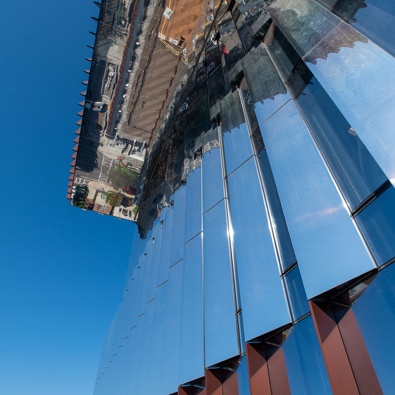 Photo: Zoomed in view of the Center for Computing and data Sciences from Commonwealth Ave. From this viewpoint, the sides of the building alternate a copper color and a reflective mirror side.