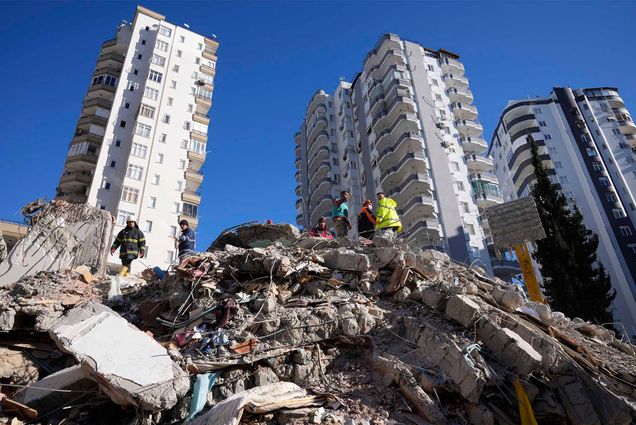 FILE - Emergency teams search for people in the rubble of a destroyed building in Adana, southern Turkey, Tuesday, Feb. 7, 2023. The Turkish government has for years tempted fate by not enforcing modern construction codes at the same time it was allowing — and in some cases, encouraging — a real estate boom in earthquake-prone areas, according to experts in geology and engineering who repeatedly issued warnings. (AP Photo/Hussein Malla)