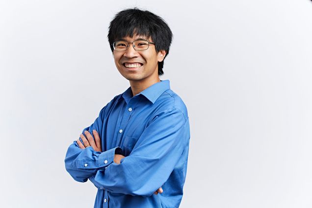 Studio portrait of Mark Bun in San Francisco, CA on September 28, 2018. He is a young, Asian man with short black hair and glasses. He smiles, his arms crossed, and wears a blue collared shirt.