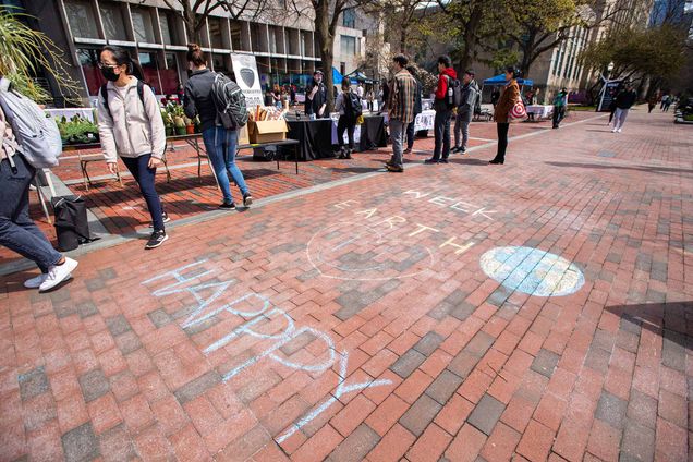 Photo: A brick sidewalk with chalk words that read "HAPPY EARTH WEEK" with a simple drawing of the Earth next to the word, earth.