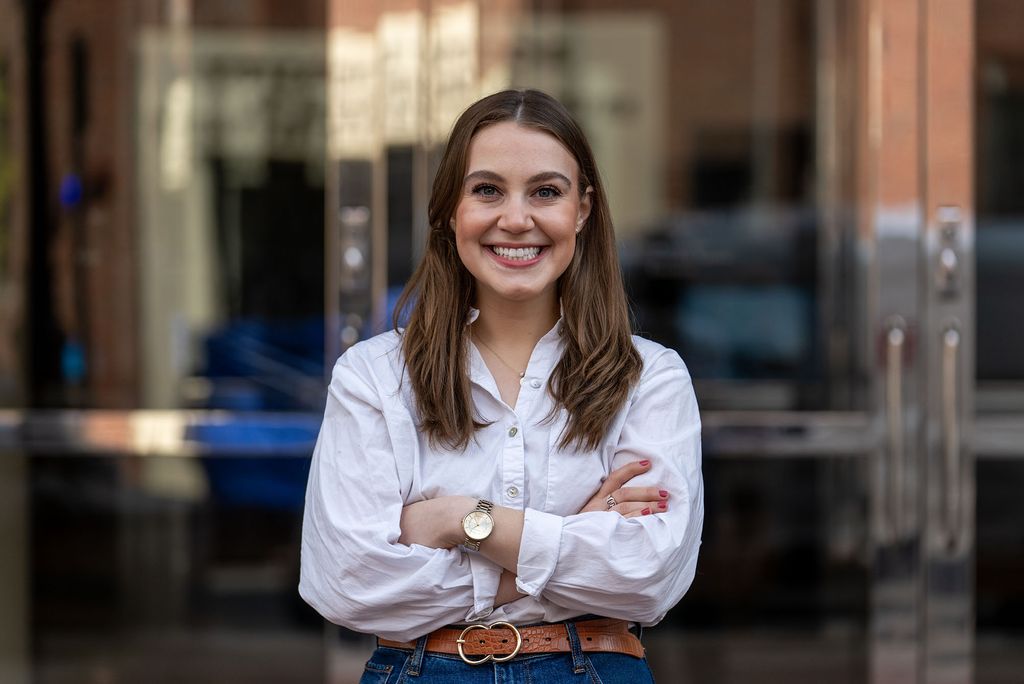 Photo: Grad student Lindsey Cohen, a young white woman wearing a white shirt, poses for a thumbnail photo for her terriers in charge video produced by the BU Today team.