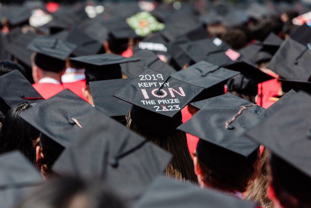 Photo: A crowd of graduation caps with one in the middle that reads: "KEEP MY EYE ION THE PRIZE"