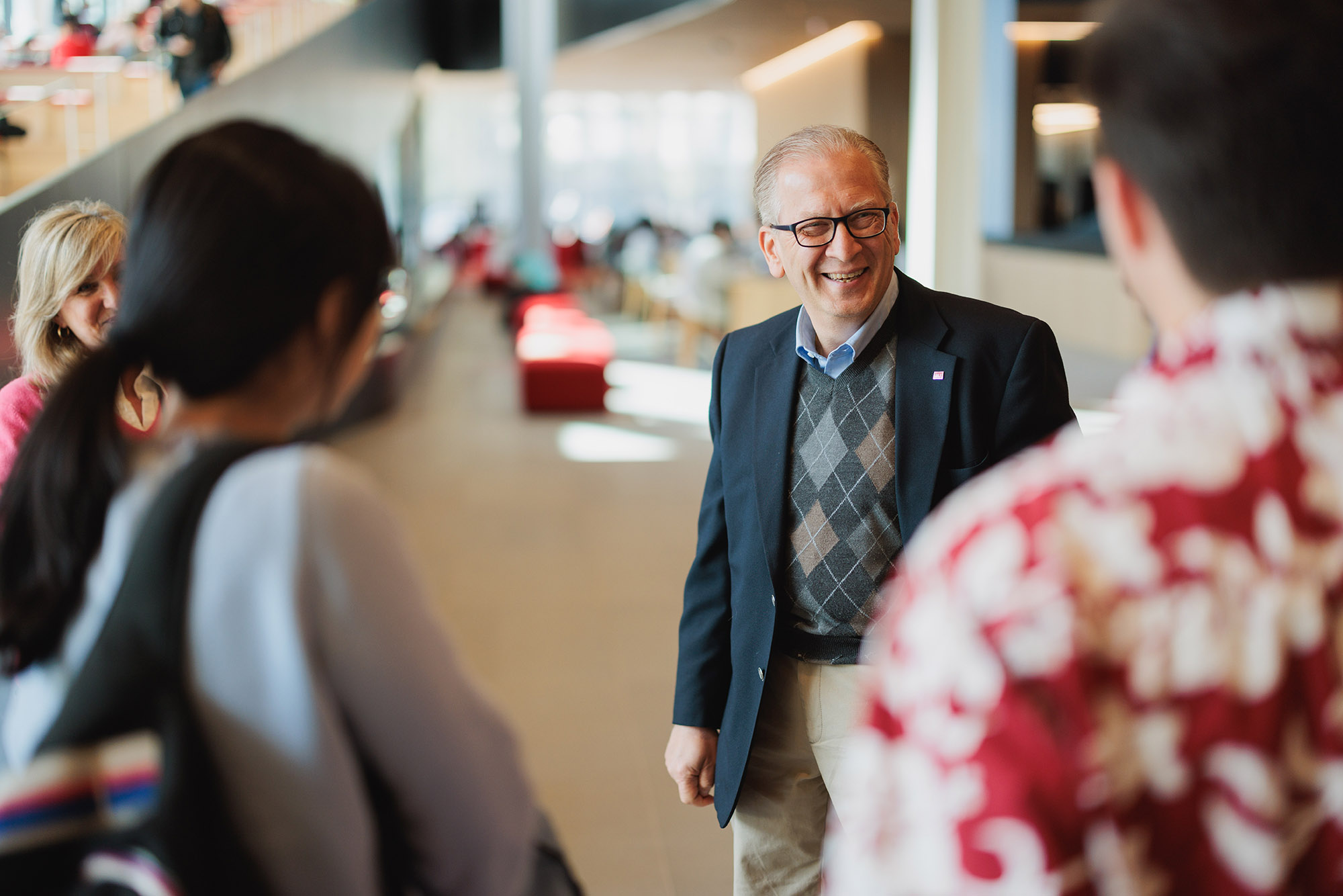 Photo: Azer Bestavros, Associate Provost for Computing and Data Sciences, speaks to the first CDS graduates on April 24th. A white man with receding silver gray hair and wearing glasses, a plaid sweater vest, navy blazer, and tan slack, laughs as he looks towards two students.