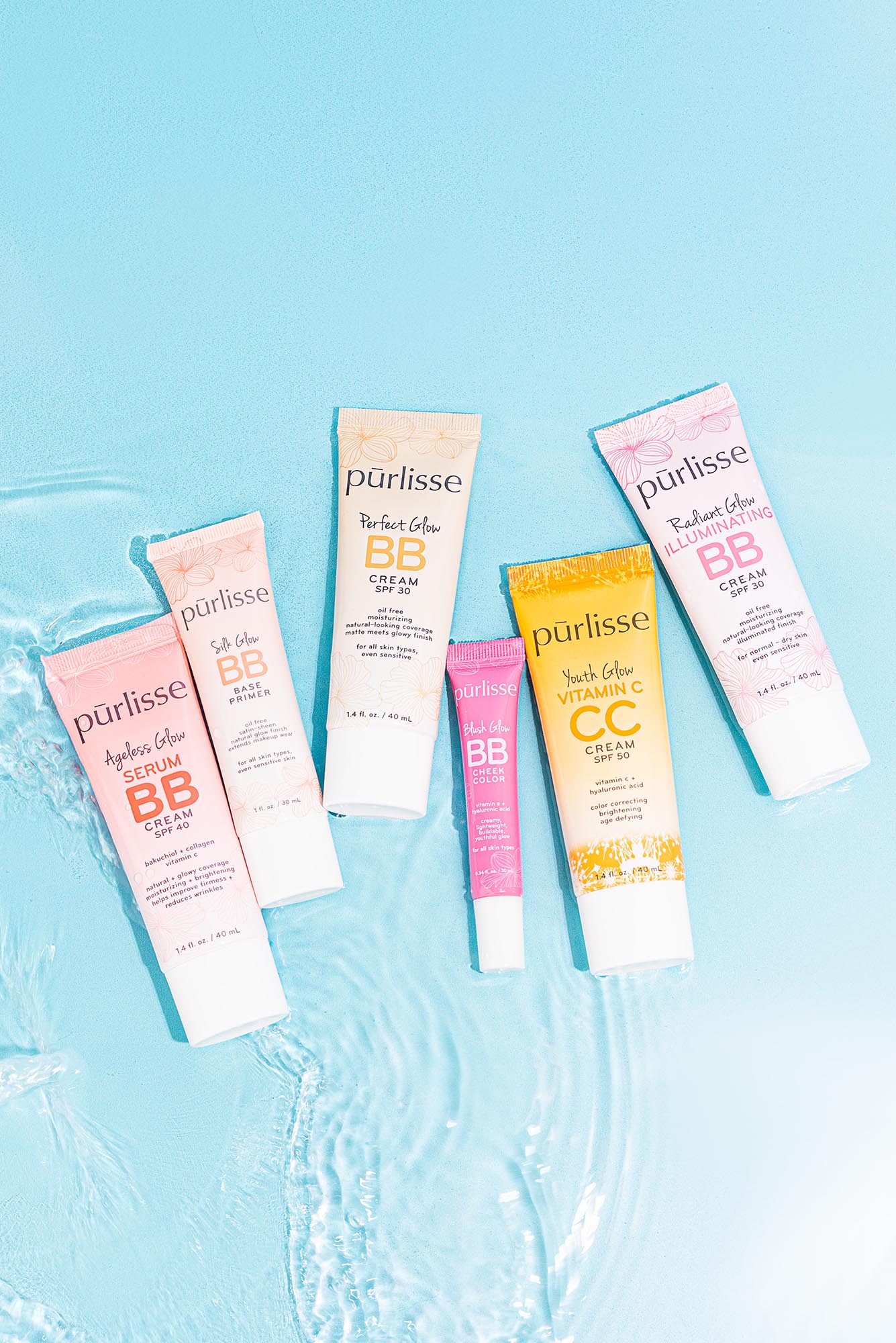 Photo: A bright blue background with water and six bottle products facing upward. They have pink, salmon, and orange-colored packaging.