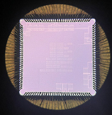 Photo: Close up image of a purple sensor microchip. Shown on a black background.