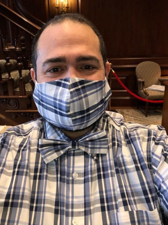 Photo of Jesus Nater with a matching mask, bowtie, and shirt with a blue and white plaid pattern.