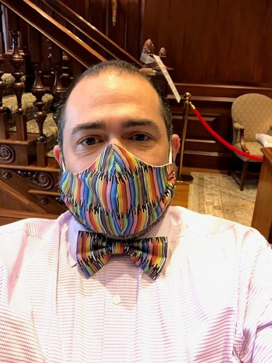 Photo of Jesus Nater with a matching mask and bowtie that has a rainbow pattern on it.