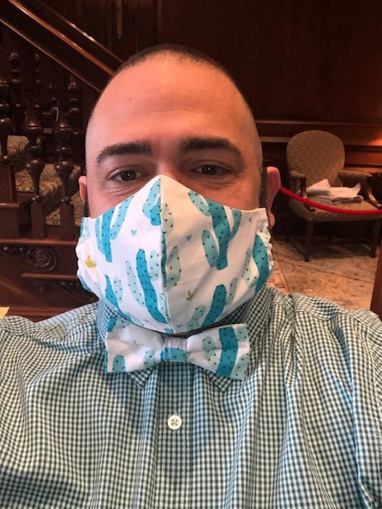Photo of Jesus Nater with a matching mask and bowtie that have a white and light teal cactus pattern.