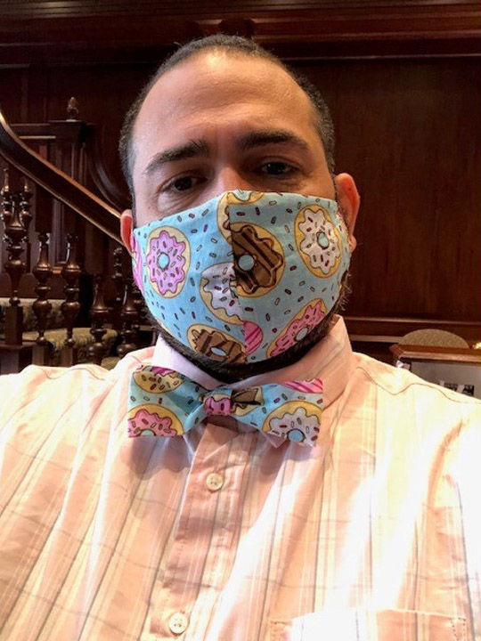 Photo of Jesus Nater with a matching mask and bowtie that is light blue with a sprinkle and donut pattern.