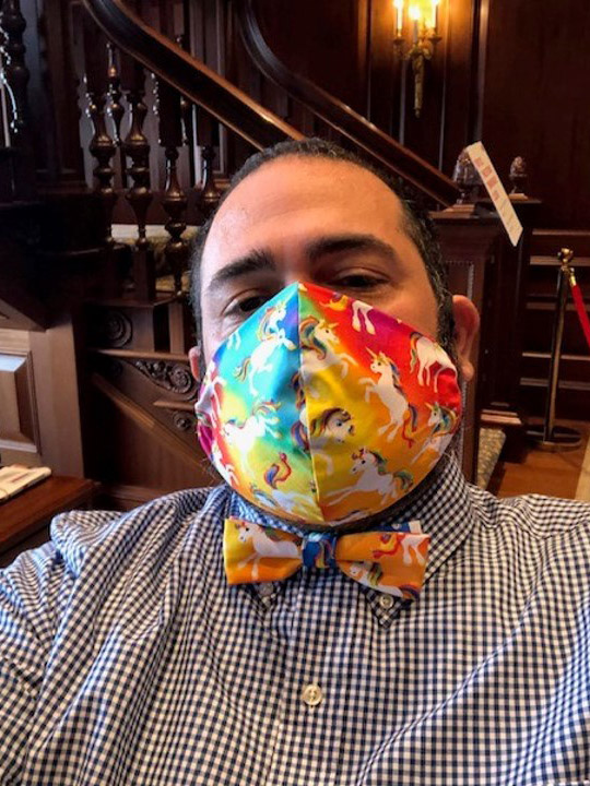 Photo of Jesus Nater with a matching mask and bowtie that is rainbow with white unicorns on it.