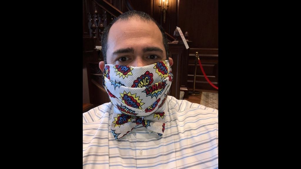 Photo of Jesus Nater with a matching mask and bowtie that is white with a pattern of comic book style speech bubbles on it that say "BAM" and "BANG"