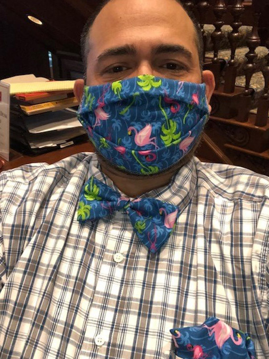 Photo of Jesus Nater with a matching mask and bowtie that is dark blue with a pink flamingo and palm tree pattern.