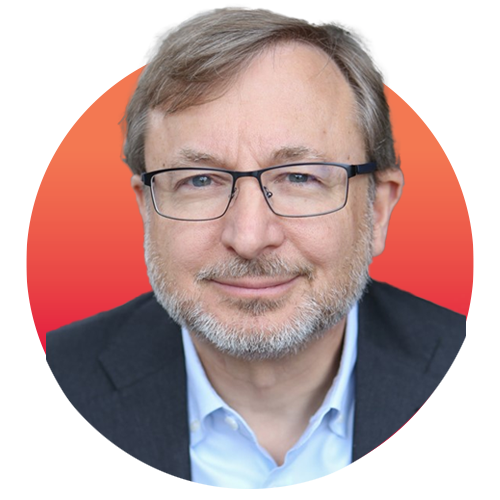 Image: Headshot photo of Peter Wexler, a white man with gray-brown hair wearing glasses, a light blue collared shirt, and black blazer. He smiles and poses for the camera. Headshot is overlaid over a red-orange gradient circle.