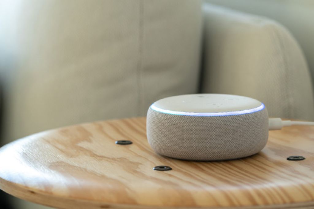 Photo: An amazon "echo" sitting on a wooden stool in a living room