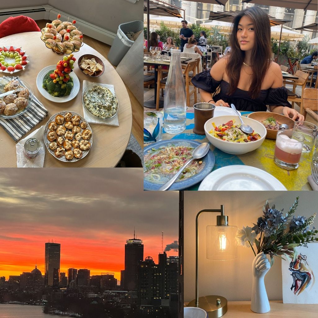 This is a photo collage of different images from Robin Kim (COM, CAS'24). The image in the left hand corner is of food spread across a dining table. There are six different dishes that all look like pastries and breakfast foods. The photo to the right of that is of Robin Kim (COM, CAS'24) and she is straight faced sitting at a dining table. She has brown hair and fair skin. She's wearing a black off the shoulder top and in front of her, there is a meal on the table. It appears she is at a restaurant. The photo below that is a desk set up. It is a wooden desk with a lamp that has a glass shade. Next to that is a flower vase that is ceramic and is in the shape of a hand. There are purple flowers in the vase. Next to the vase is a minature canvas with a color small drawing on the canvas. To the left of that photo is a sunset on the Boston skyline. The sky is orange and grey and the buildings look like a silhouette against the sky. 