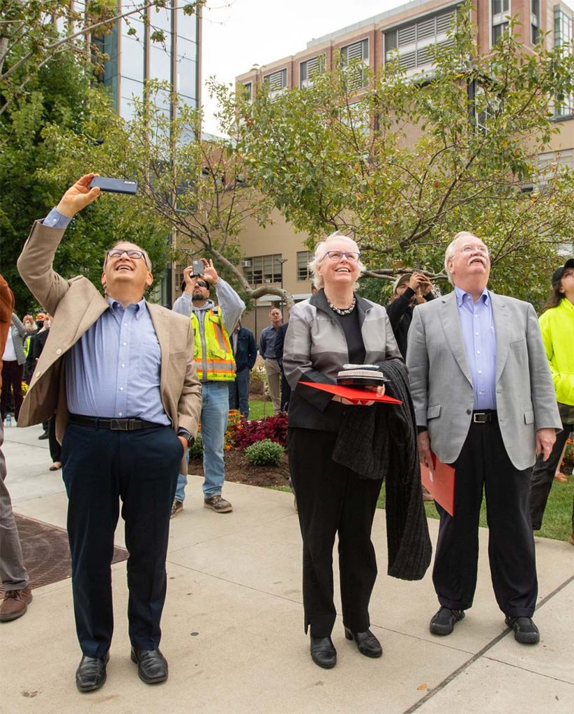 Onlookers including President Robert A Brown, from right, Provost Jean Morrison, and Azer Bestaveros watch as the final beam is put into place during the Topping Off ceremony at the Data Sciences Building September 30.