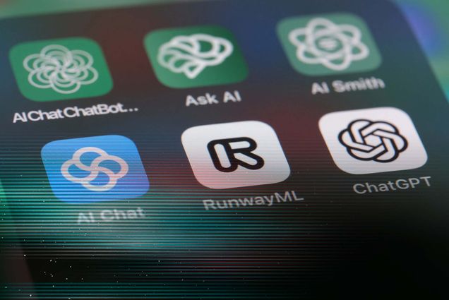 Image: A zoomed in photo of a phone screen showing icons for OpenAI ChatGPT and other AI application software.