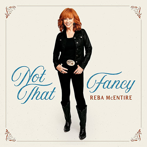 Image: Album cover of Reba McEntire's "Not That Fancy". McEntire, a white woman with curly auburn hair and wearing an all black outfit, stands and poses on a cream white background. Text around her reads "Not that fancy" is elaborate script font.