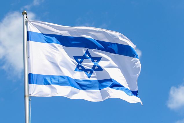 Photo: An Israeli flag, blue and white with a star of David centered.