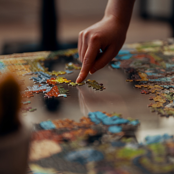 Photo: Zoomed in photo shows a small hand putting together a puzzle.
