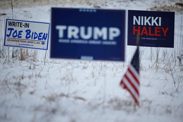 Photo: Two political lawn signs in a snowy yard, one for Trump and one for Nikki Haley, next to a sign endorsing Joe Biden for president as a write in.