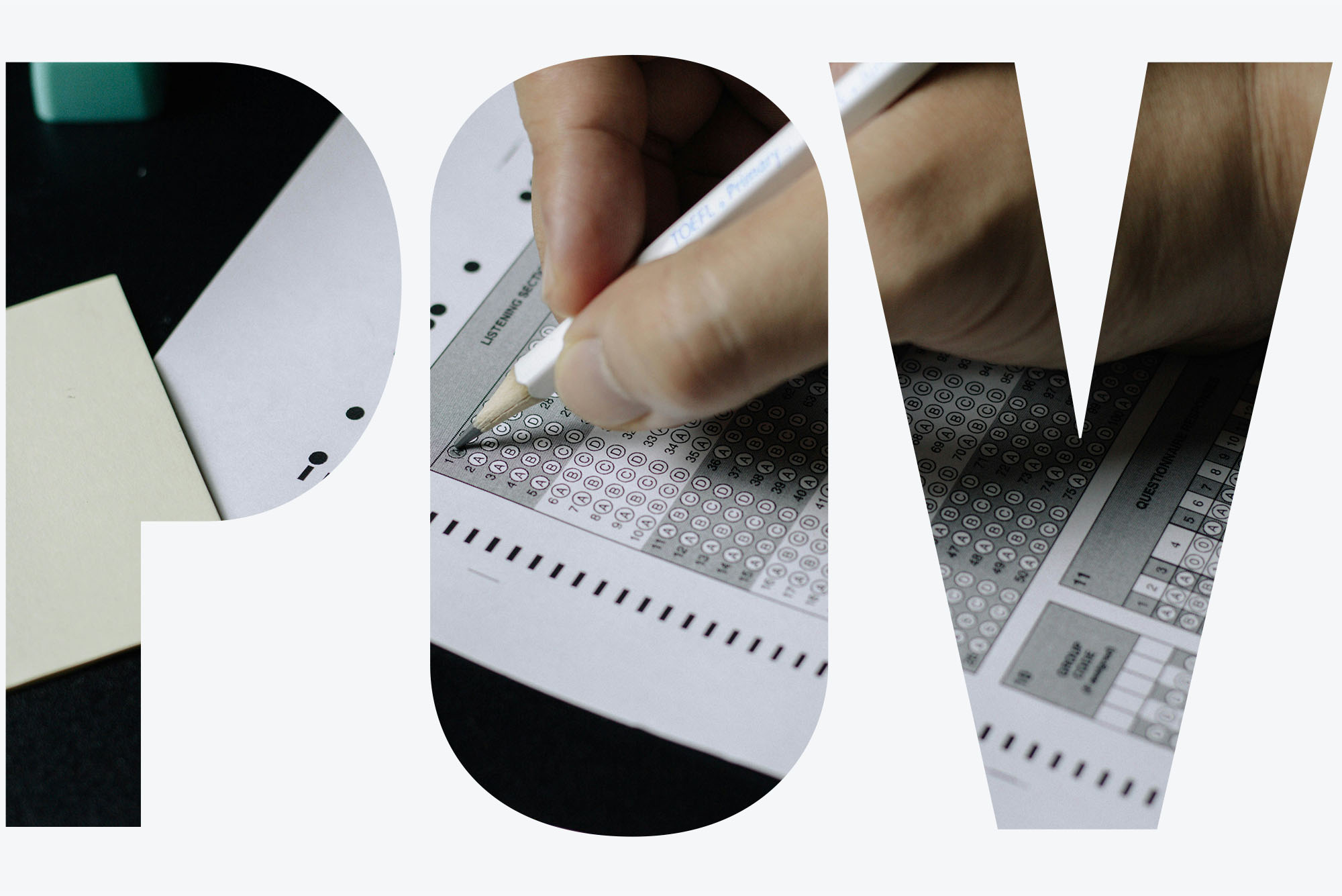 Photo: A hand holding a pencil filling in bubbles on a standardized test. The letters "POV" are visible as an overlay on the image