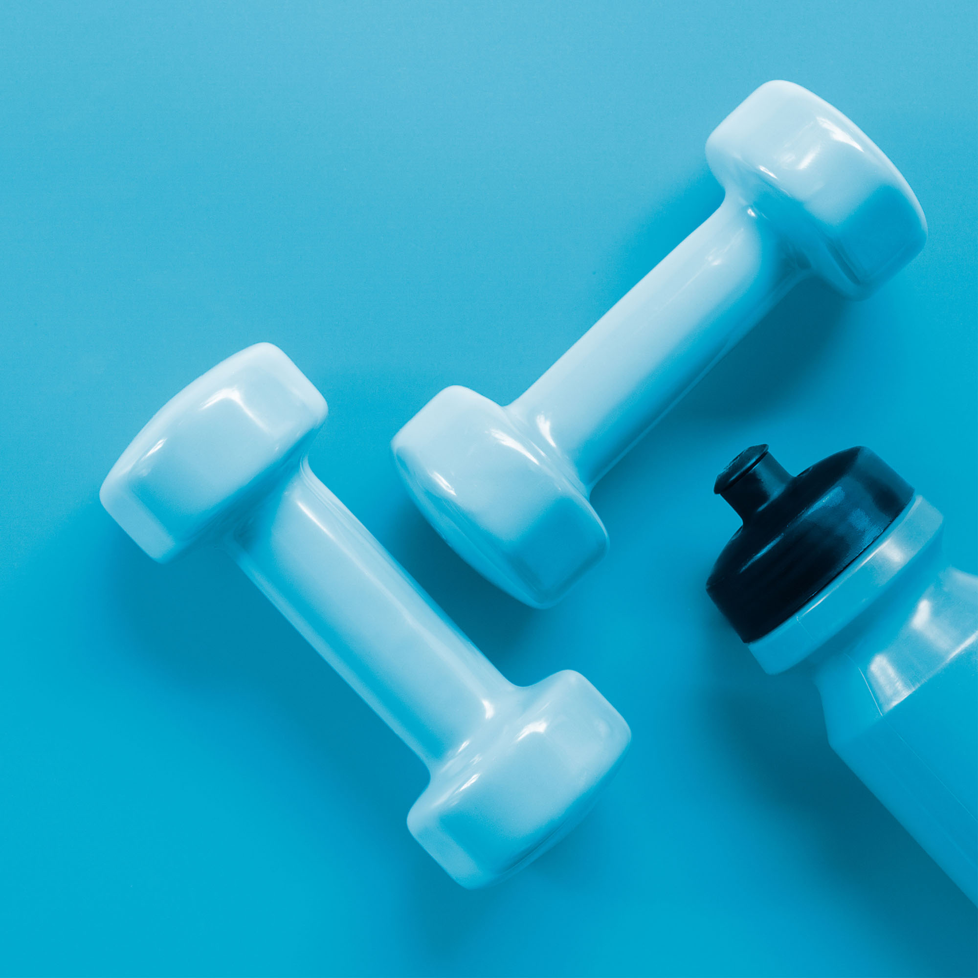 Photo: Weights and a water bottle on a blue background