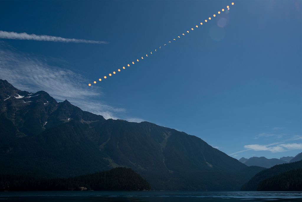 Photo: This composite image shows the progression of a partial solar eclipse over Ross Lake, in Northern Cascades National Park, Washington on Monday, Aug. 21, 2017. A total solar eclipse swept across a narrow portion of the contiguous United States from Lincoln Beach, Oregon to Charleston, South Carolina. A partial solar eclipse was visible across the entire North American continent along with parts of South America, Africa, and Europe. Photo Credit: (NASA/Bill Ingalls)