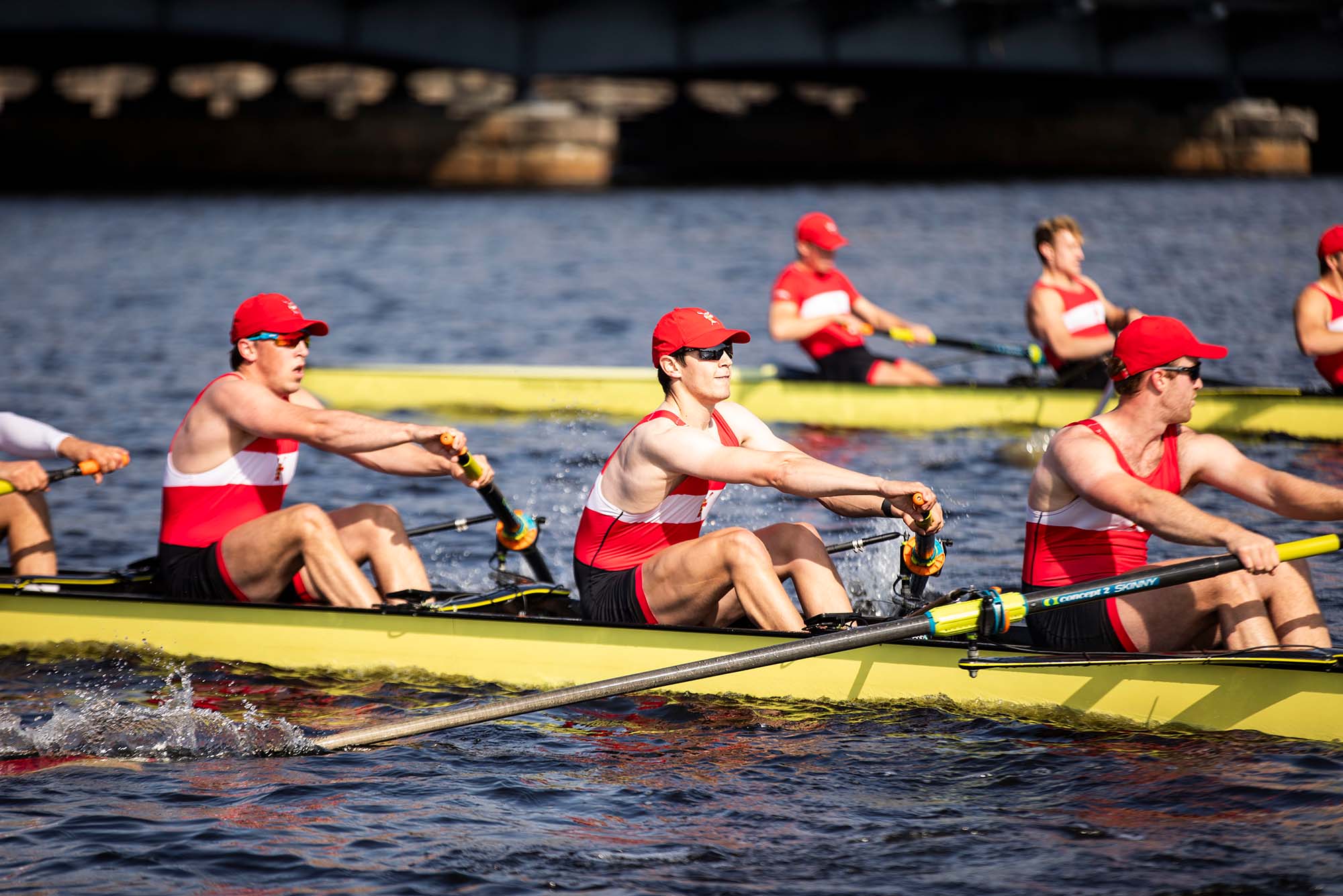 Photo: A picture of a men's team rowing wearing clothes with red accents