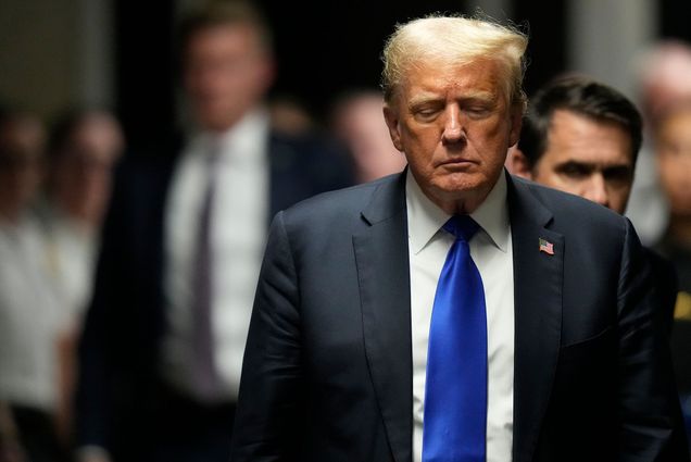 Photo: Donald Trump, an aging man in a blue suit, walks out of a court room with a somber look on his face