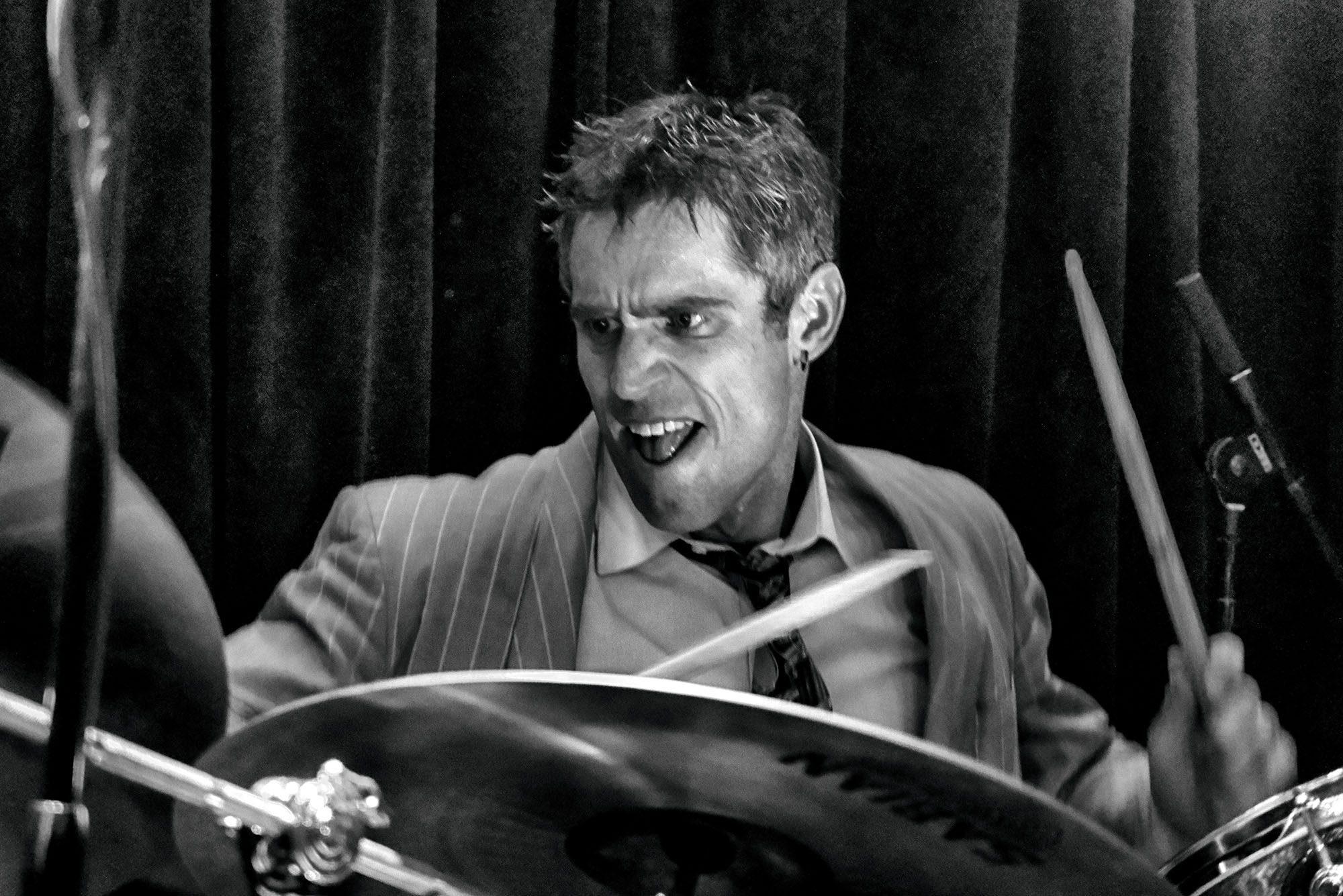 Photo: A black and white picture of Gareth Dylan Smith, a CFA professor, playing the drums on stage