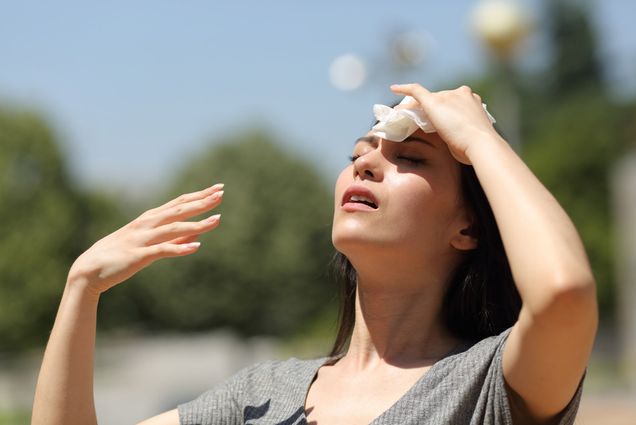 Photo: Asian woman drying sweat in a warm summer day