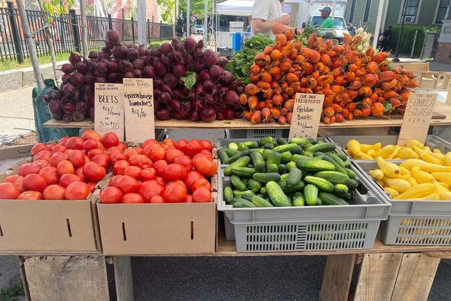 Photo: A picture of a farmer's market stand with tomatoes, cucumbers, squash, and beets