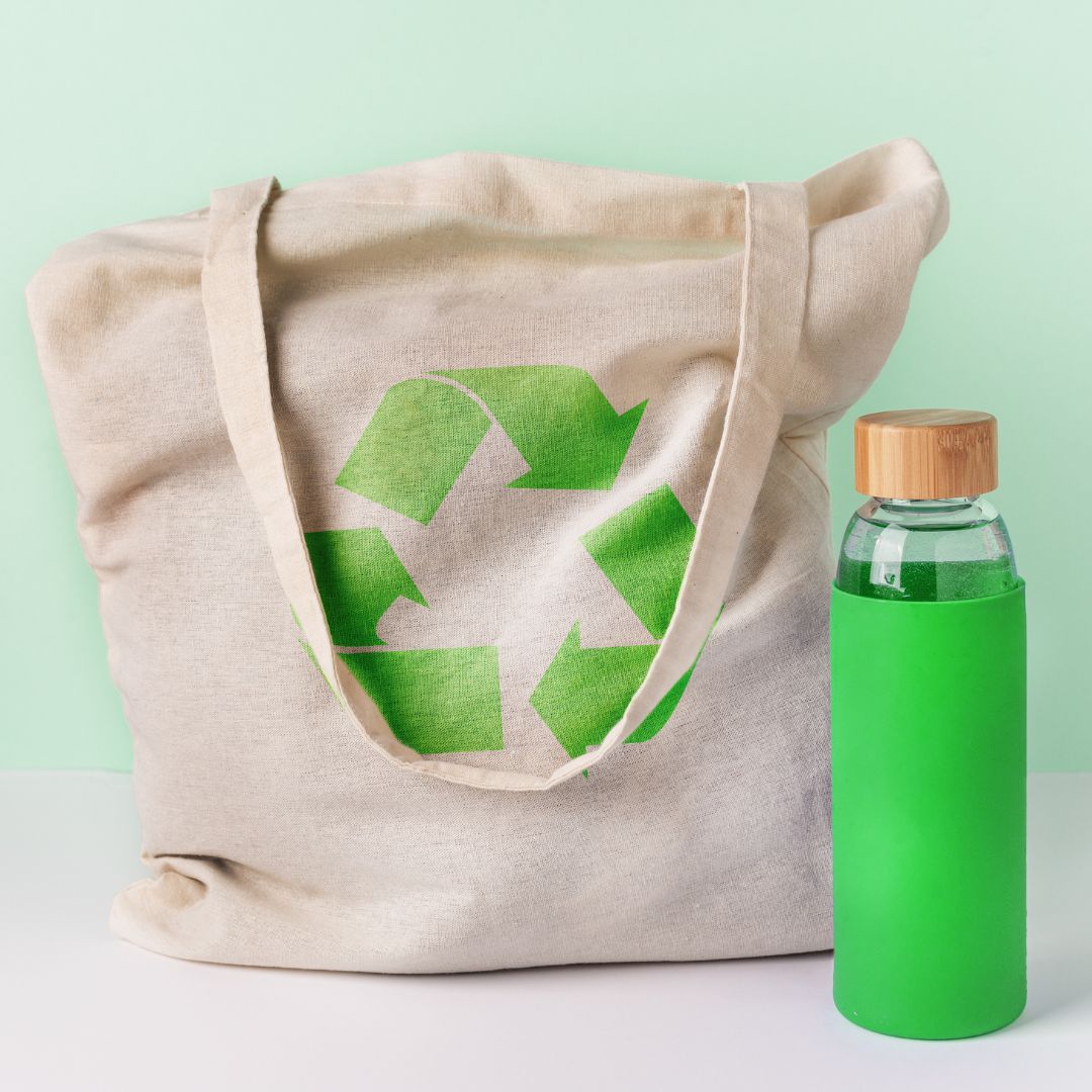 Photo: Natural cotton eco shopping bag and a glass reusable water bottle. Zero waste concept.