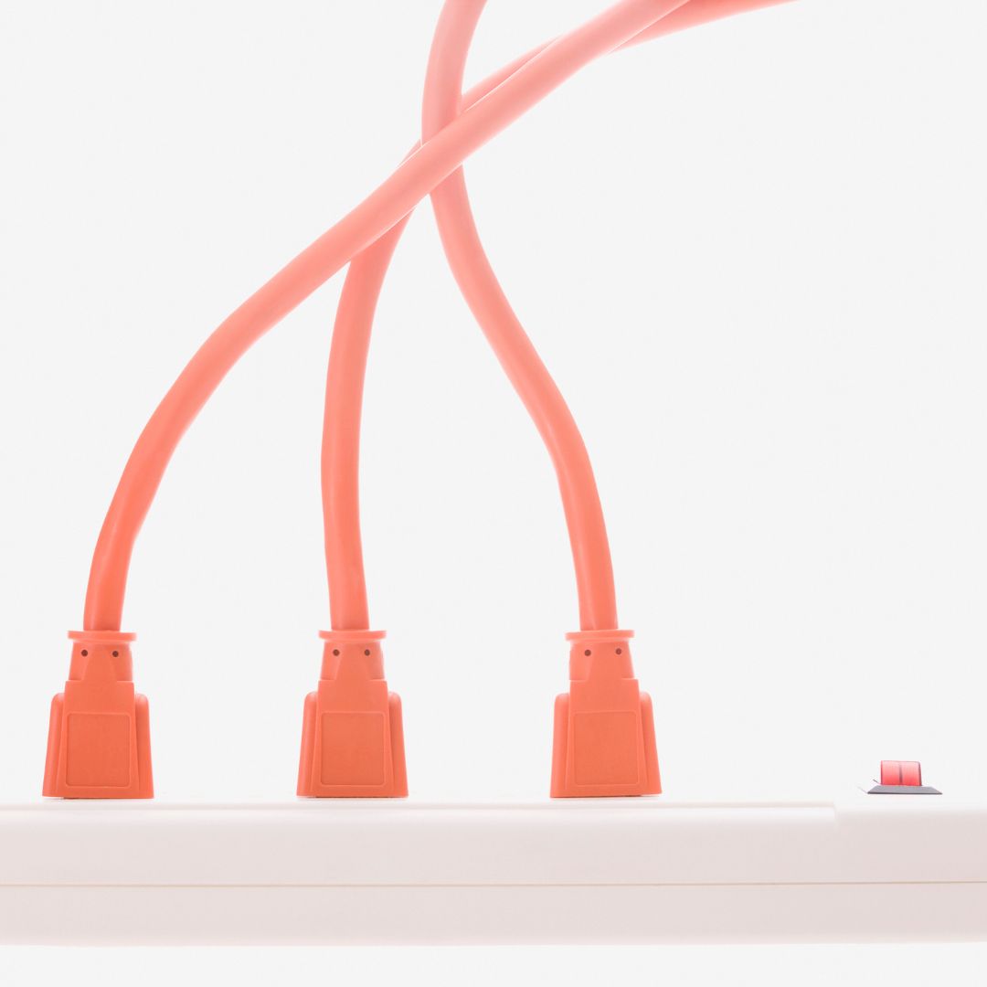 Photo: Orange power cords plugged into a power strip
