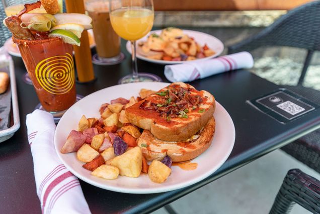 Photos: A picture from an outdoor meal at Lulu's Allston. There are two large pieces of toast next to a stack of breakfast potatoes.