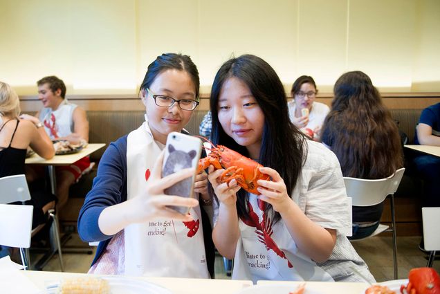 Photo: Sipei Fu (SAR 19) , left and Jie Ling (COM 19) take a selfie with a lobster during lobster night