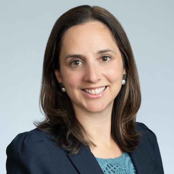 Photo: A woman in a suit with short dark hair poses for a formal headshot
